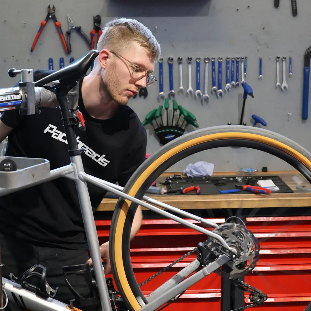 Werkstattmitarbeiter bei Trionik in der Werkstatt am Fahrrad.